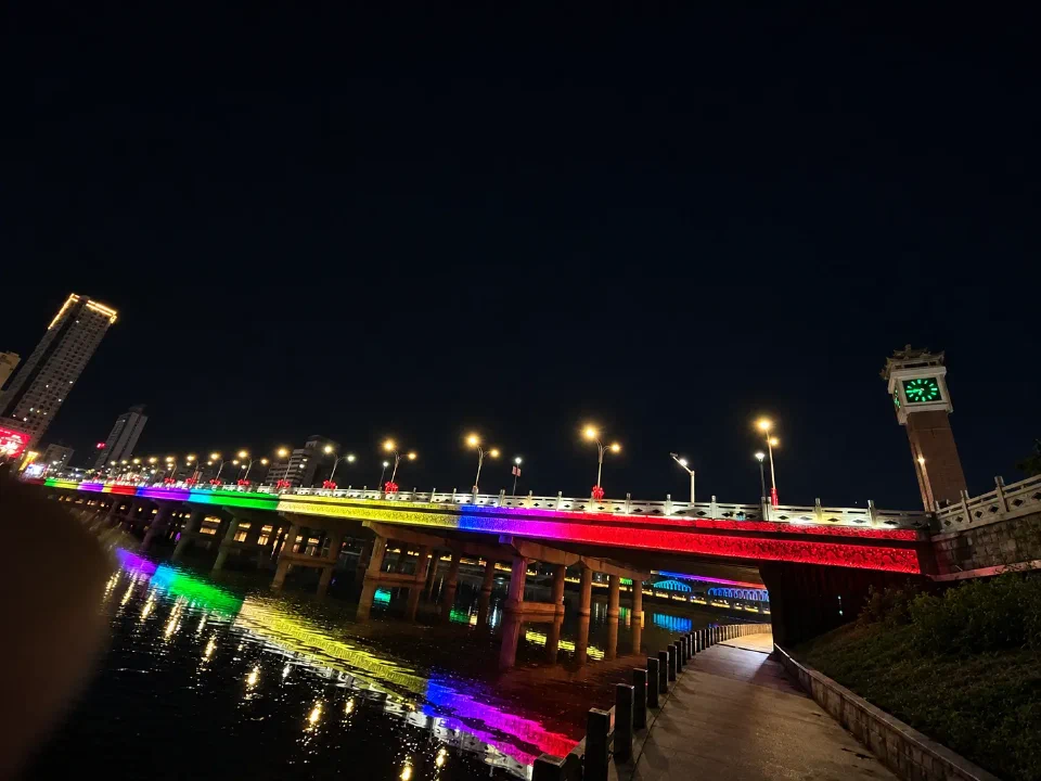 承德大桥的彩色灯光与河中倒影，四面钟静静立在桥头